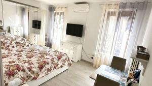 a white bedroom with a bed and a tv at Da Enzo in Desenzano del Garda