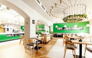 un restaurante con paredes verdes, mesas de madera y sillas en Grandhotel Brno en Brno