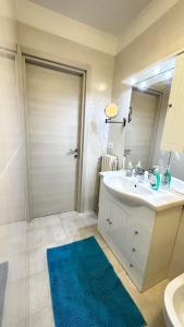 baño con lavabo blanco y alfombra azul en Da Enzo, en Desenzano del Garda