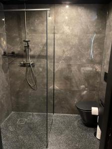 a bathroom with a glass shower with a toilet at Hotel 83 in Amsterdam