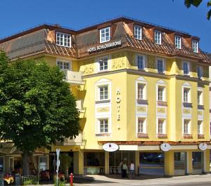 żółty budynek po stronie ulicy w obiekcie Hotel Schlosskrone w Füssen