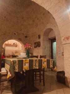 a dining room with a table with a stone wall at Gasphouse in Castellana Grotte