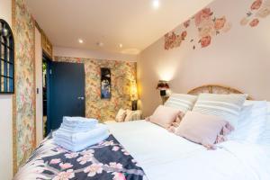 een slaapkamer met een bed met witte lakens en roze kussens bij The Emerald Suite by Margate Suites in Margate