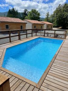 een groot blauw zwembad op een houten terras bij chalet des Illes SAINT MARTIN IIII in Prat-et-Bonrepaux