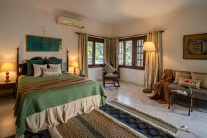 a bedroom with a large bed and a couch at LohonoStays Homestead, Corbett in Rāmnagar