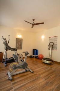 um ginásio com 2 bicicletas de exercício e uma ventoinha de tecto em LohonoStays Homestead, Corbett em Ramnagar