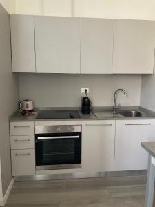 a kitchen with white cabinets and a stove and a sink at BOITO36 in Campi Bisenzio +33 photos