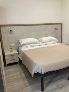 a bedroom with a large bed with white sheets and pillows at BOITO36 in Campi Bisenzio