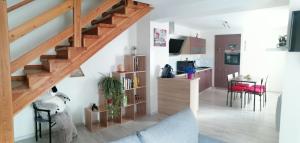 a living room with a staircase and a dining room at Gîte de rarounette au cœur des Vosges in Celles-sur-Plaine