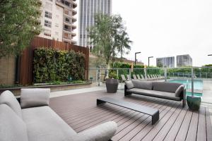 a patio with two couches and a table and a pool at Downtown 1BR w Gym Pool nr Disney Concert Hall LAX-372 in Los Angeles