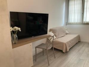 a living room with a large television and a chair at BOITO36 in Campi Bisenzio