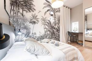 um quarto com uma grande cama branca com mural de palmeiras em MY CASA - LA CROIX - Old Town - Modern apartment, 2 bedrooms em Nice
