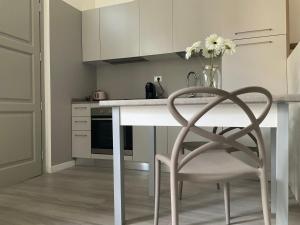 a kitchen with a table and a chair with a vase of flowers at BOITO36 in Campi Bisenzio