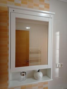 un espejo con un jarrón en un estante del baño en Apartamento Alfa, en Monforte de Lemos