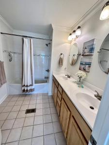 a bathroom with a sink and a tub and a shower at Sea La Vie Townhouse in Navarre