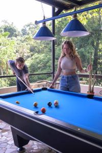 a man and a woman playing a game of pool at Hostal Portobelo in Portobelo