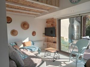 een woonkamer met een bank, een tv en een tafel bij Apartment Port et golf-8 by Interhome in Anglet