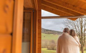 a bride and groom looking out the window of a cabin at NETTEN Naturerlebnis Holz-Chalets in Daun