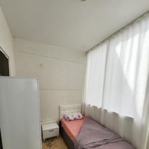 um pequeno quarto com uma cama e uma janela em Sea Wave House em Alanya