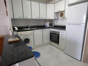 - une cuisine avec des placards blancs et un lave-linge/sèche-linge dans l'établissement Apartment Ordre de Malta by Interhome, à Sant Carles de la Ràpita