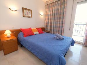 - une chambre dotée d'un lit bleu avec des oreillers rouges et jaunes dans l'établissement Apartment Ordre de Malta by Interhome, à Sant Carles de la Ràpita