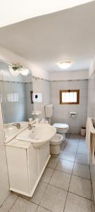 uma casa de banho branca com um lavatório e um WC em B&B Francesca em Calascibetta