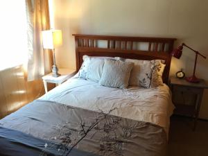 ein Schlafzimmer mit einem großen Bett mit weißer Bettwäsche und Kissen in der Unterkunft Classic Carnelian Bay Log Cabin in Carnelian Bay