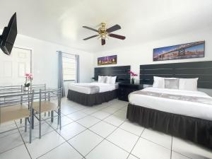 a hotel room with two beds and a ceiling fan at The Blue Wave in Hollywood