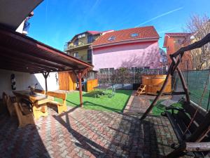 a backyard with a patio with a table and a playground at Casa Carol in Tăşnad