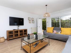 een woonkamer met een bank en een tv bij Villa Neus by Interhome in Lloret de Mar