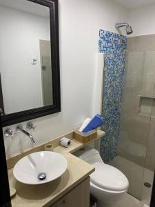 a bathroom with a toilet and a sink and a shower at Apartamento frente a la playa in Cartagena de Indias