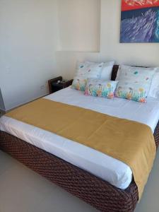 a bedroom with a large bed with white sheets and pillows at Apartamento frente a la playa in Cartagena de Indias