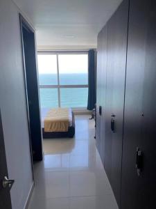 a room with a bedroom with a bed and a window at Apartamento frente a la playa in Cartagena de Indias