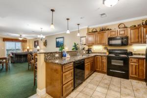 a kitchen with wooden cabinets and a living room at Summit Manor Condos Unit B3052 in Gatlinburg