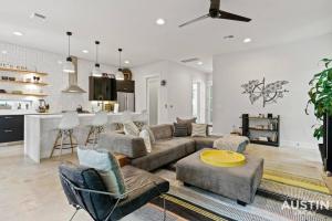 sala de estar con sofá y sillas y cocina en Picture-Perfect Trendy Vibes Minutes From Rainey, en Austin