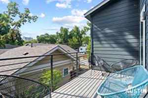 un balcón con 2 sillas y una casa en Picture-Perfect Trendy Vibes Minutes From Rainey, en Austin