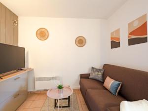 een woonkamer met een bank en een tv bij Apartment Résidence Villa Toscane by Interhome in Saint-Raphaël