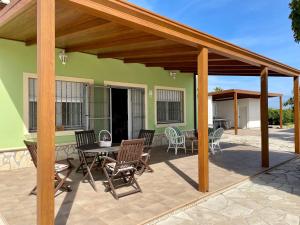 un patio con pérgola de madera, mesa y sillas en lola, en Denia