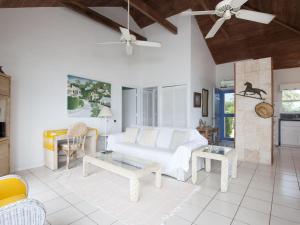 uma sala de estar com um sofá branco e uma mesa em Pebbles cottage em Governorʼs Harbour