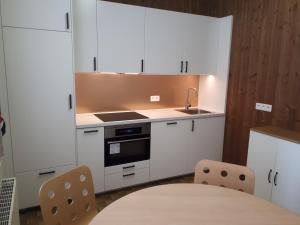 a kitchen with white cabinets and a table and chairs at Columbia in Ostend