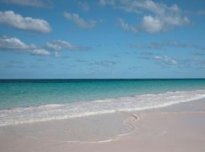 a sandy beach with the ocean and a blue sky at Coriolana home in Savannah Sound