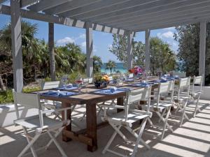 a wooden table and chairs on a patio with the ocean at Coriolana home in Savannah Sound