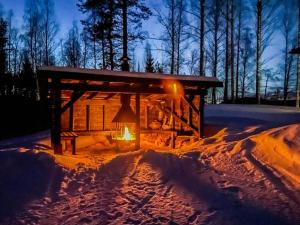 a cabin with a lantern in the snow at night at Holiday Home Hot pool cottage kesäranta by Interhome in Ihamaniemi