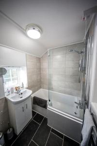 a bathroom with a shower and a tub and a sink at Cliff Stud Retreat, Helmsley, Frankel Cottage in Helmsley