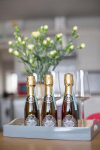 three bottles on a tray with a vase and wine glasses at Cliff Stud Retreat, Helmsley, Frankel Cottage in Helmsley