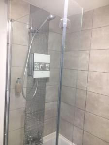 a shower with a glass door in a bathroom at Cliff Stud Retreat, Helmsley, Frankel Cottage in Helmsley