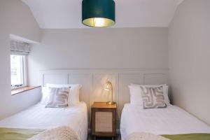 two beds sitting next to each other in a bedroom at Ava Lily Cottage, Tideswell in Tideswell