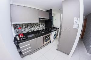 a small kitchen with a sink and a refrigerator at Apartamento Royale na praia de Boa Viagem in Recife