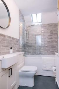 Baño blanco con aseo y lavamanos en Ava Lily Cottage, Tideswell, en Tideswell