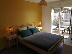 a bedroom with a bed with blue pillows and a balcony at Apartment Indigo Bay by Interhome in Le Lavandou